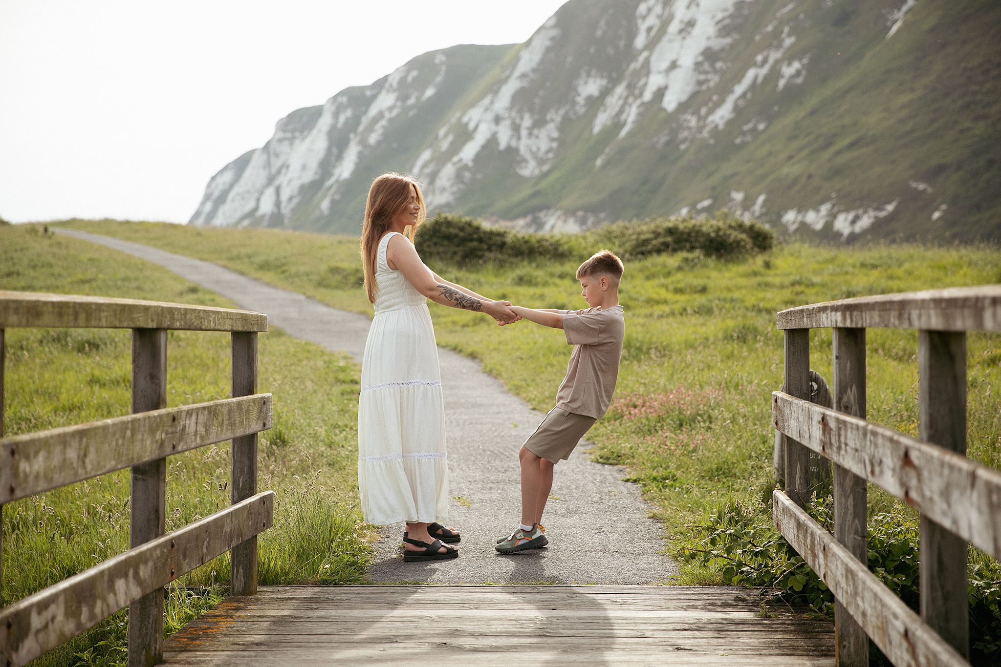 Outdoors family photography in Kent featuring a mother and son enjoying a playful moment near the White Cliffs of Dover.