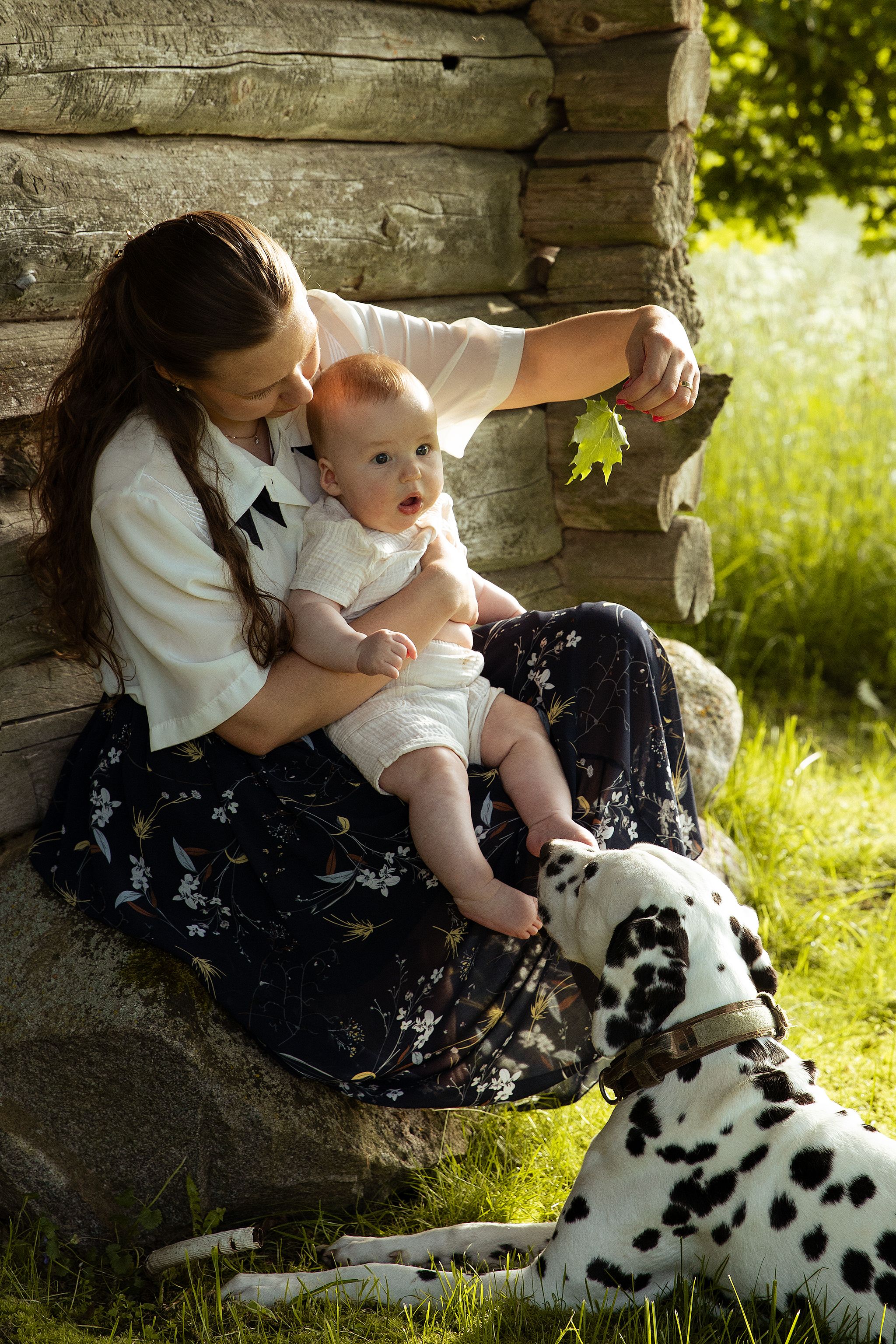 Family photography in Whitstable, Kent with mother, baby and family dog enjoying a relaxed outdoor photoshoot.