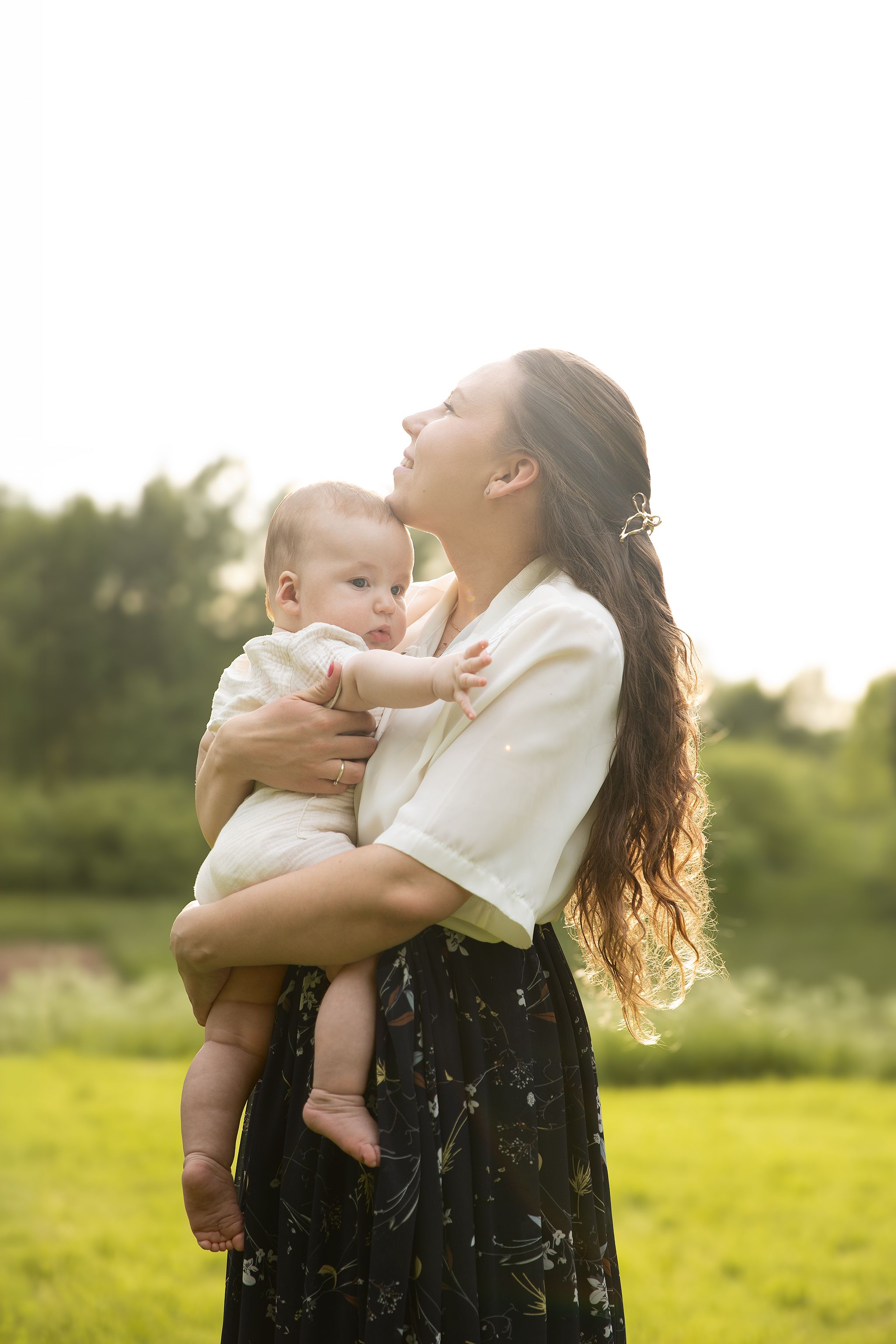 Outdoor motherhood photography session in Kent featuring a mother and a baby enjoying relaxed family photoshoot in a sunset golden hour.