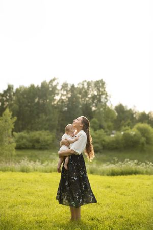 Outdoor motherhood photography session in Kent featuring a mother and a baby enjoying relaxed family photoshoot in a sunset golden hour.