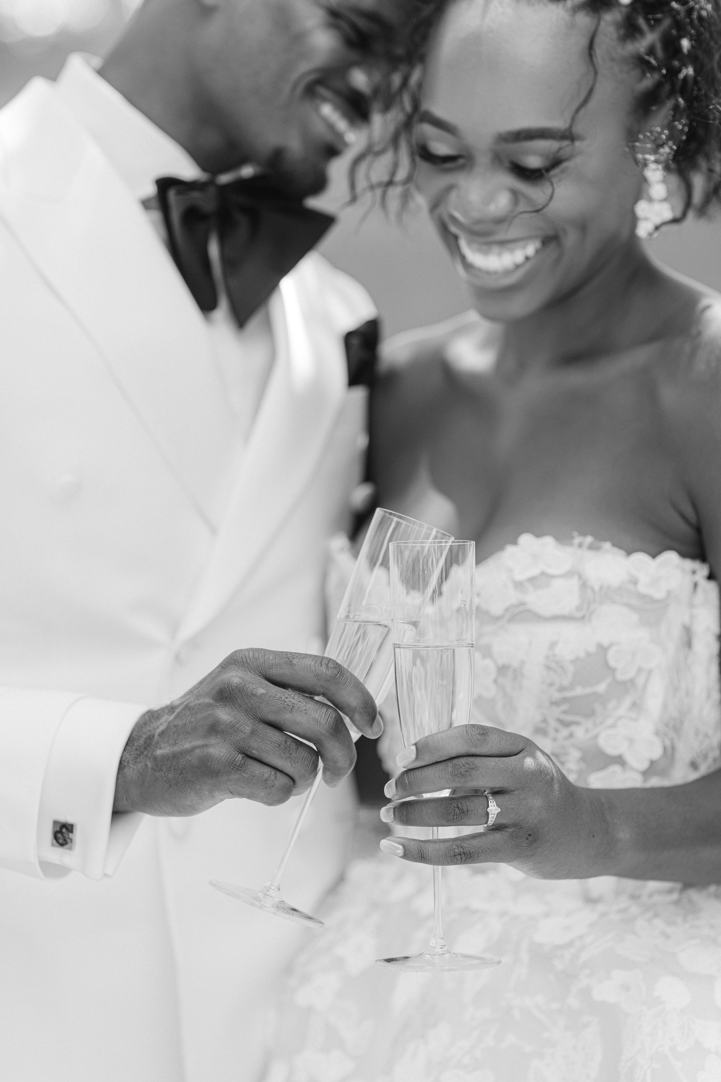 A joyful couple sharing an intimate moment with champagne glasses during their wedding celebration.