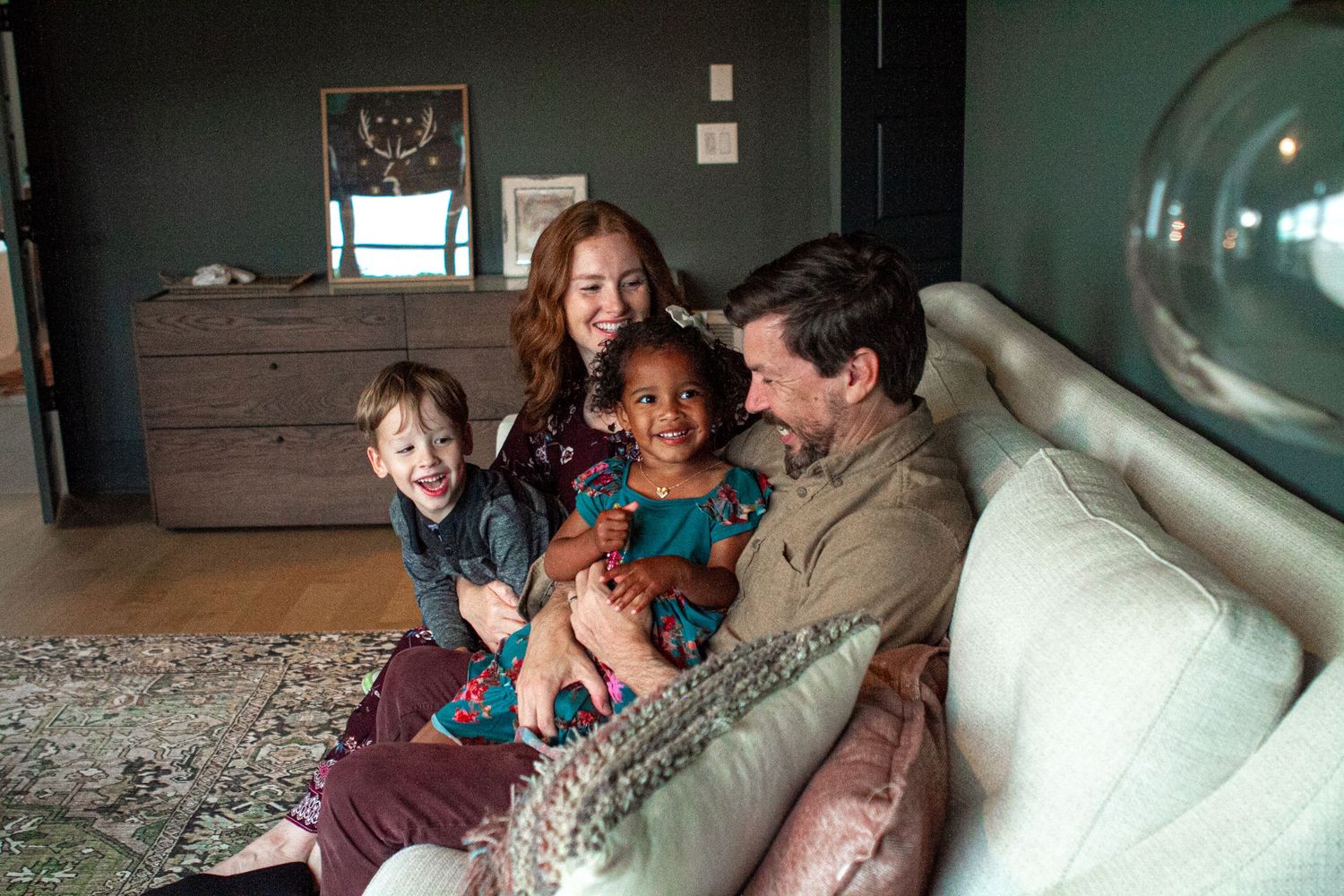 Lifestyle family photo - happy family, smiling and laughing on a couch