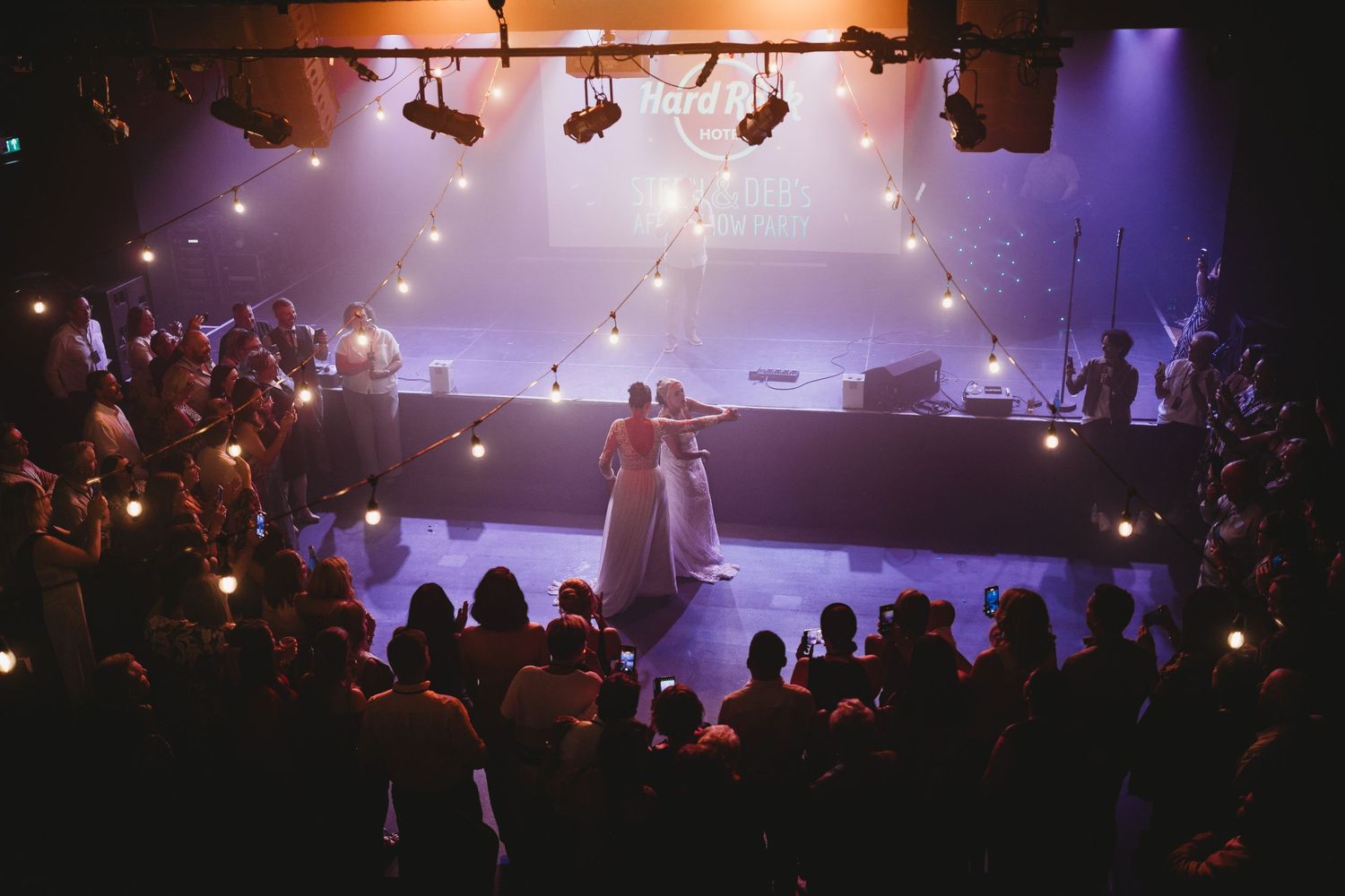 Wedding party poses in navy and pink attire against forest backdrop with smoke effects.