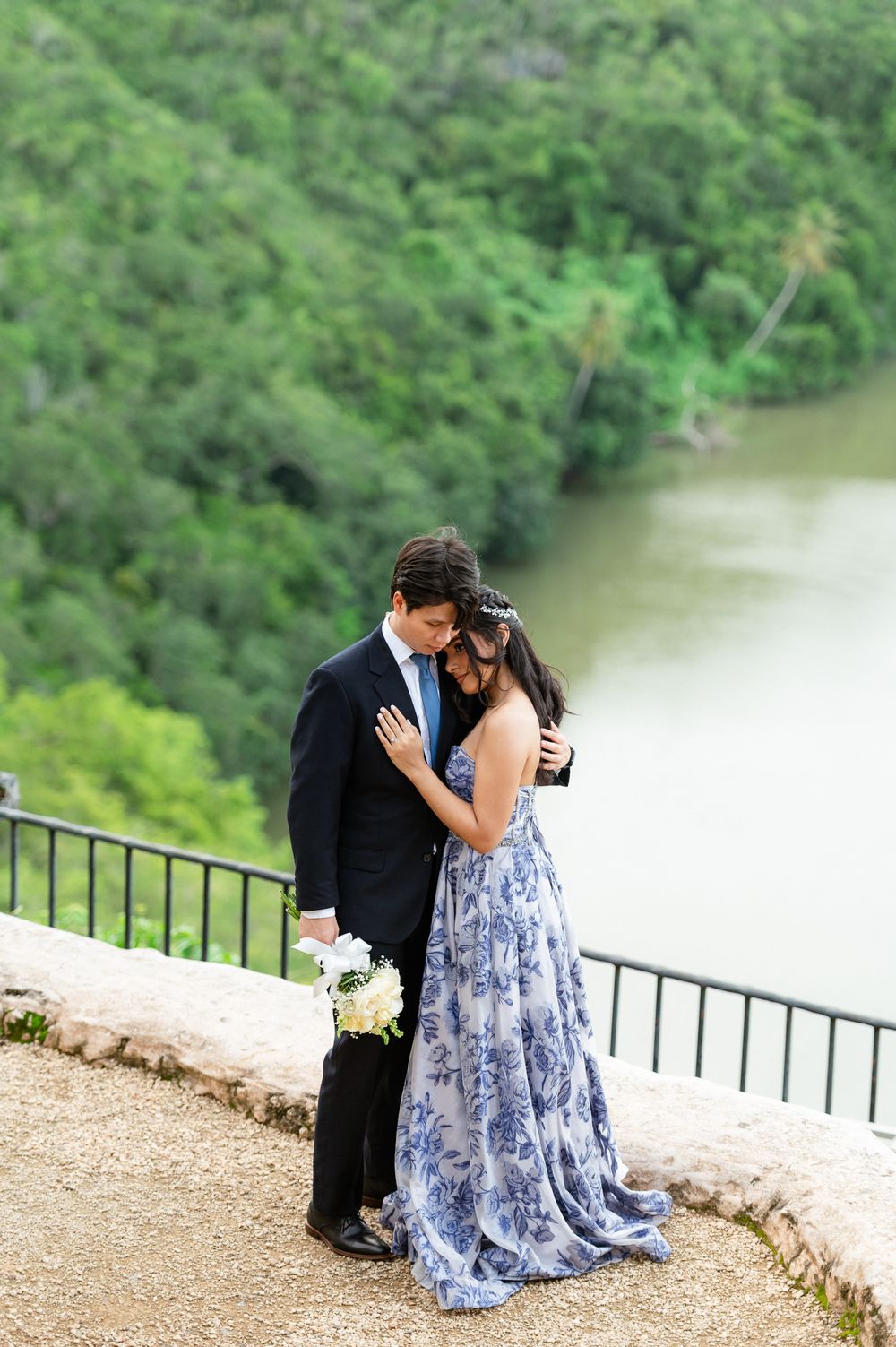 A romantic sequence of photos showing a couple in formal attire embracing on a scenic overlook by a lake.