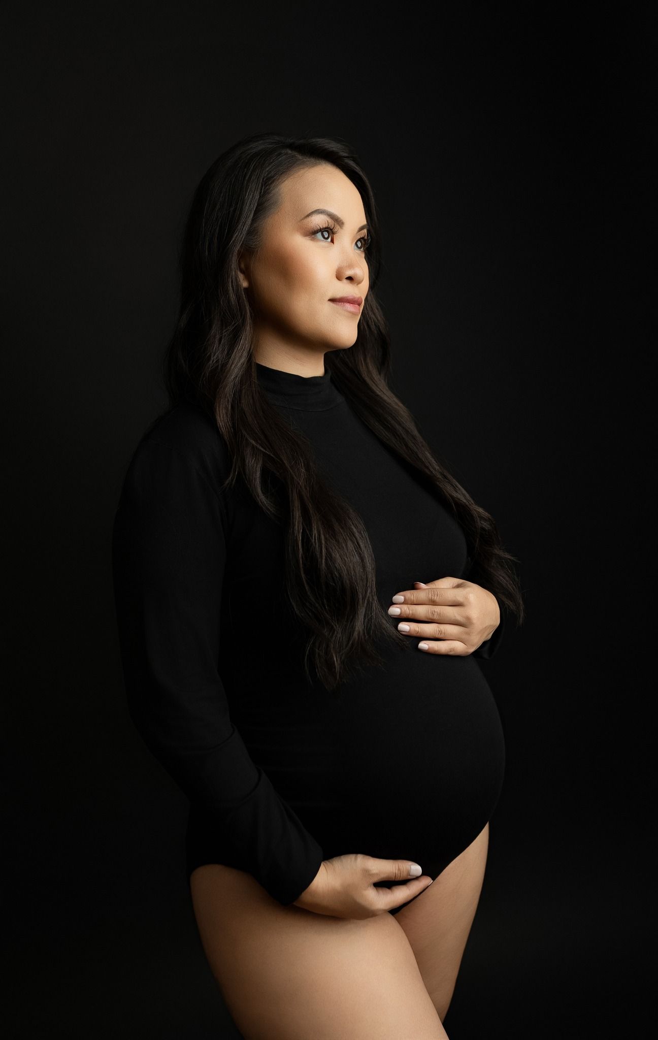 An Asian woman holding her belly in a maternity session. Greenville SC newborn photographer. - Easley Sc newborn photographer. Greenville SC