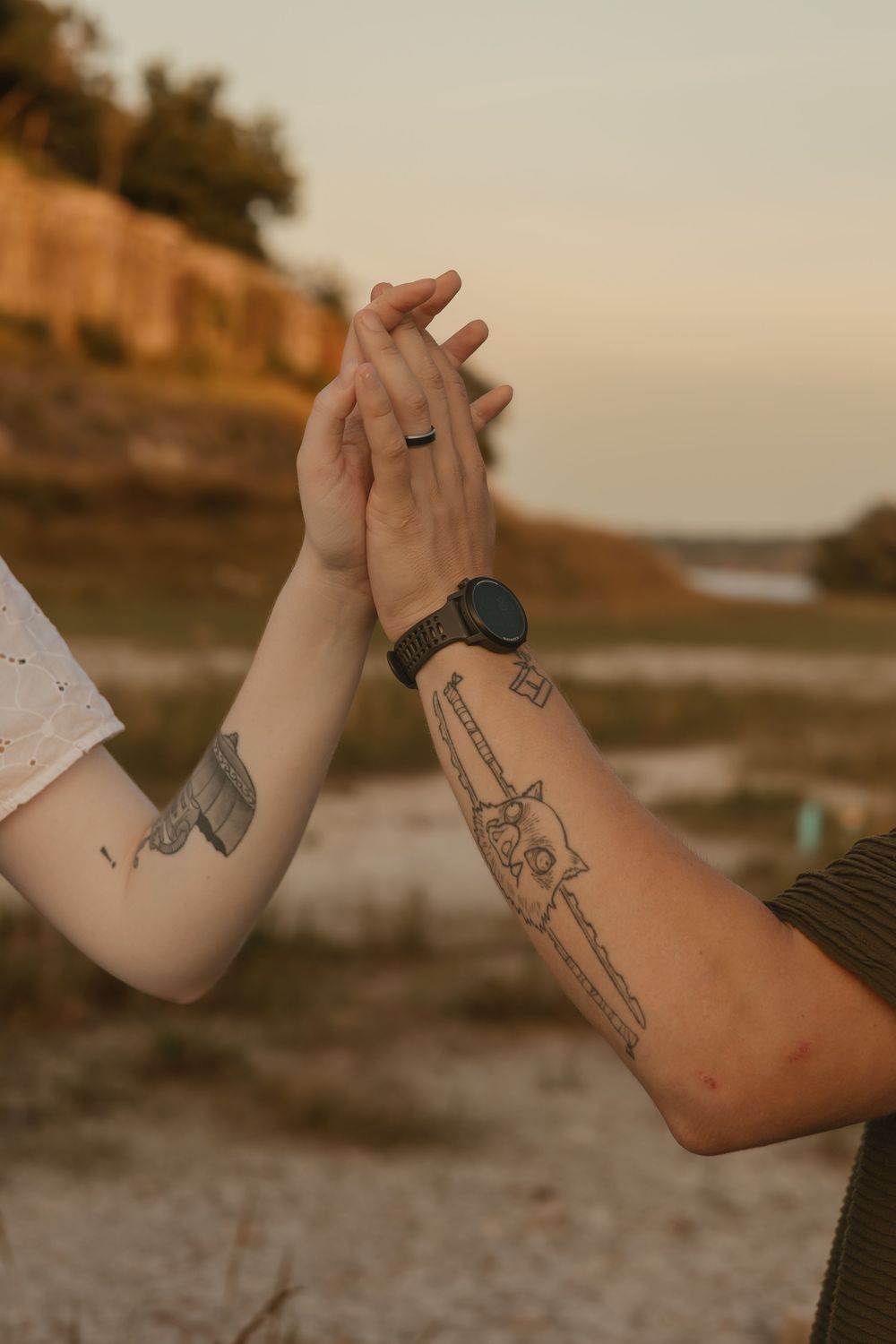 Four close-up photos showing tattooed forearms with various designs against a sunset beach background.