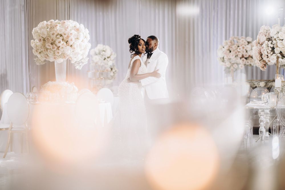 Romantic wedding reception moment with a couple sharing a dance surrounded by soft candlelight and floral decor.