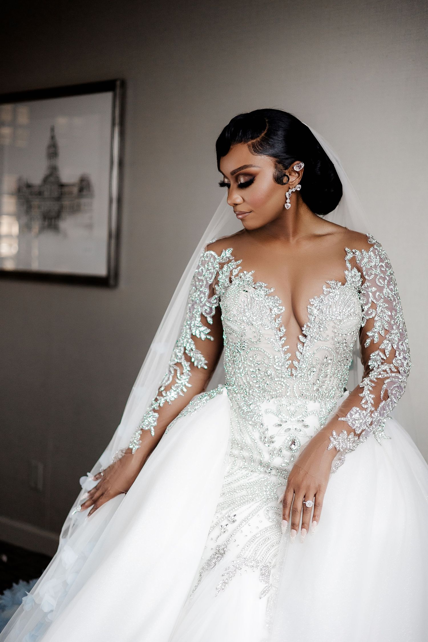 Elegant bride seated in a luxurious white gown, gazing to the side with a serene and sophisticated expression.