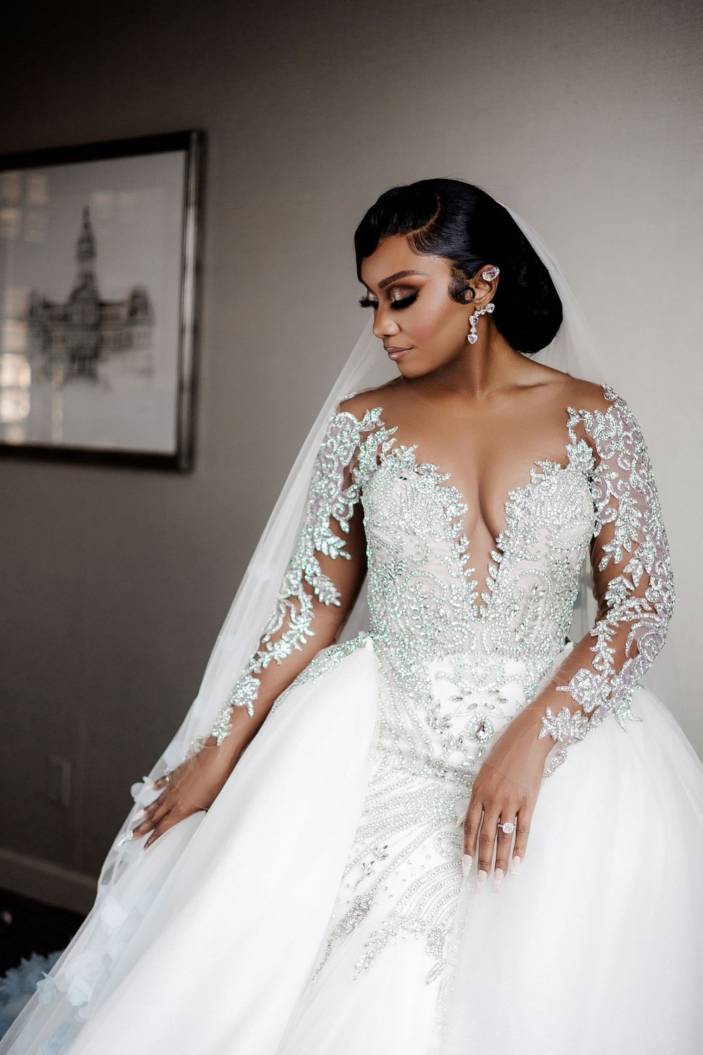 Elegant bride seated in a luxurious white gown, gazing to the side with a serene and sophisticated expression.