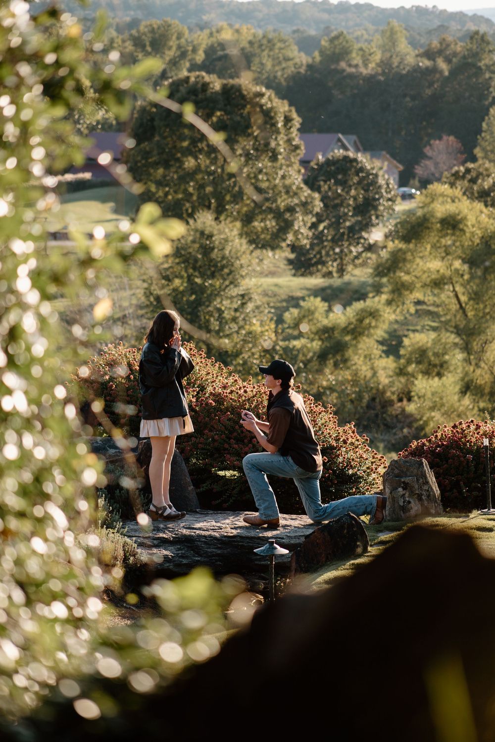 People relax on blanket during outdoor picnic in scenic hillside setting.
