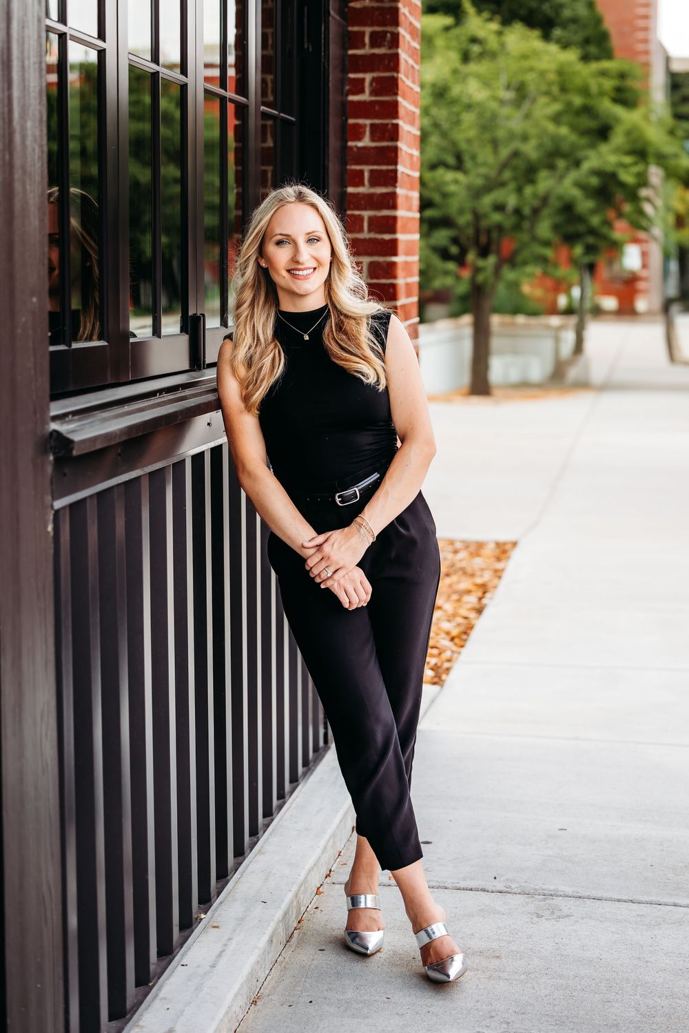 Person in business attire poses along brick building walkway in outdoor portrait series in North Haven, CT.