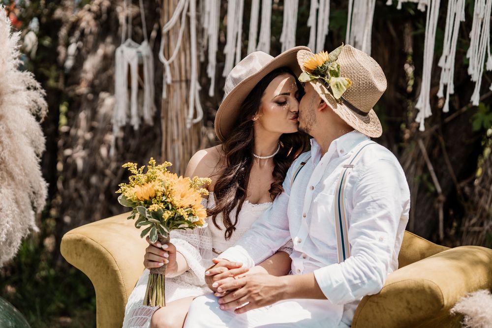 A joyful celebration with guests in white attire and sunflower decorations at an outdoor venue.