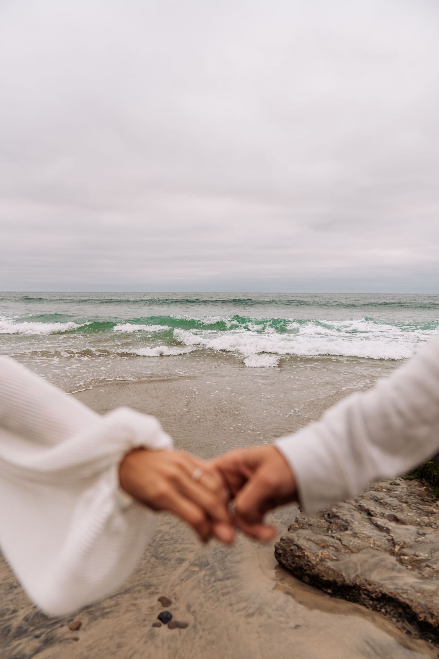 Close up image of newly engaged couple holding hands with ring on finger