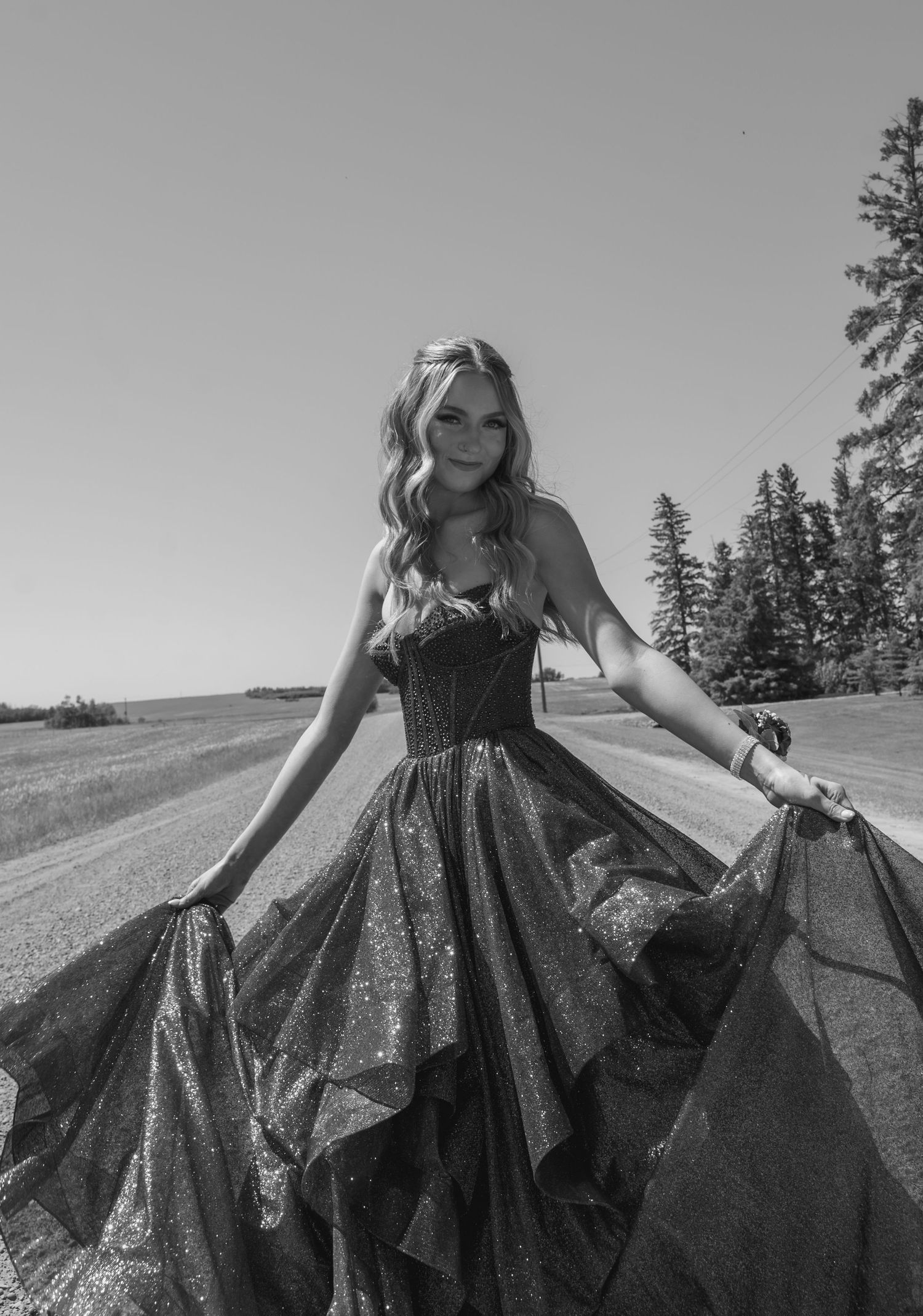 A sequence of black and white photos showing a flowing dress twirling in motion against a rural landscape backdrop.