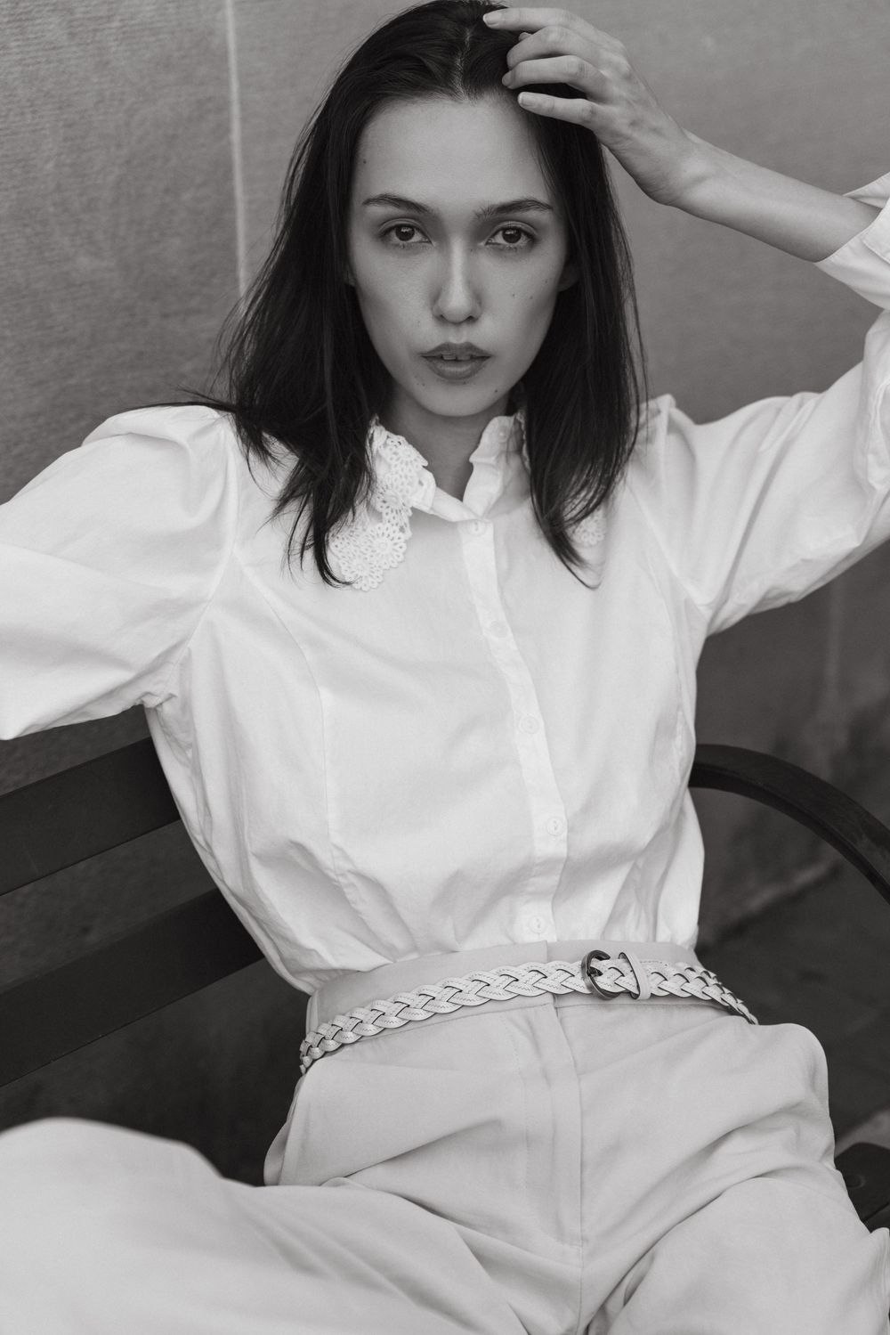 Editorial model sitting on city bench with white button down shirt and cream trousers, Atlanta editorial portrait and fashion photographer