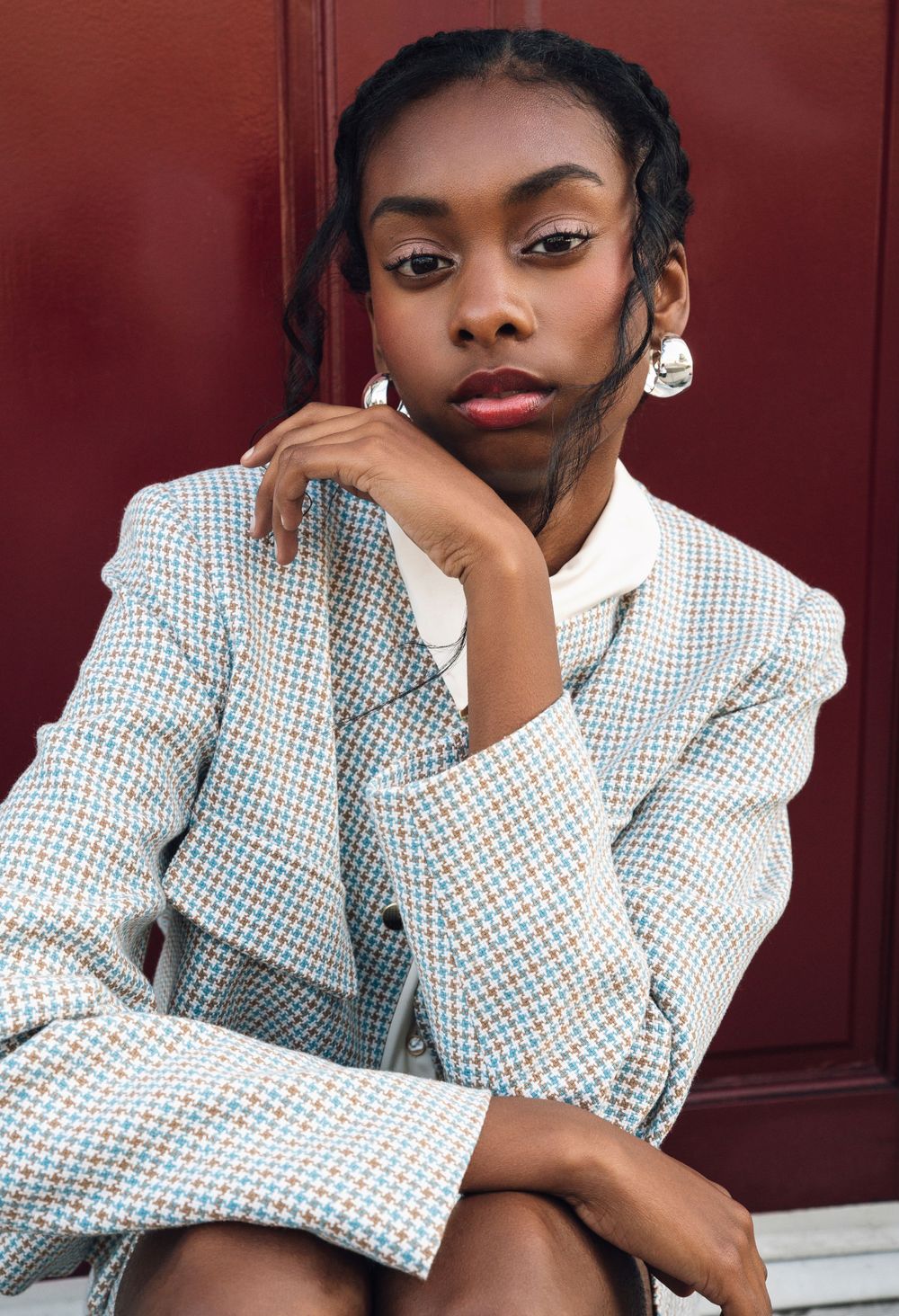 Black model sitting in front of dark red door, Atlanta editorial portrait and fashion photographer