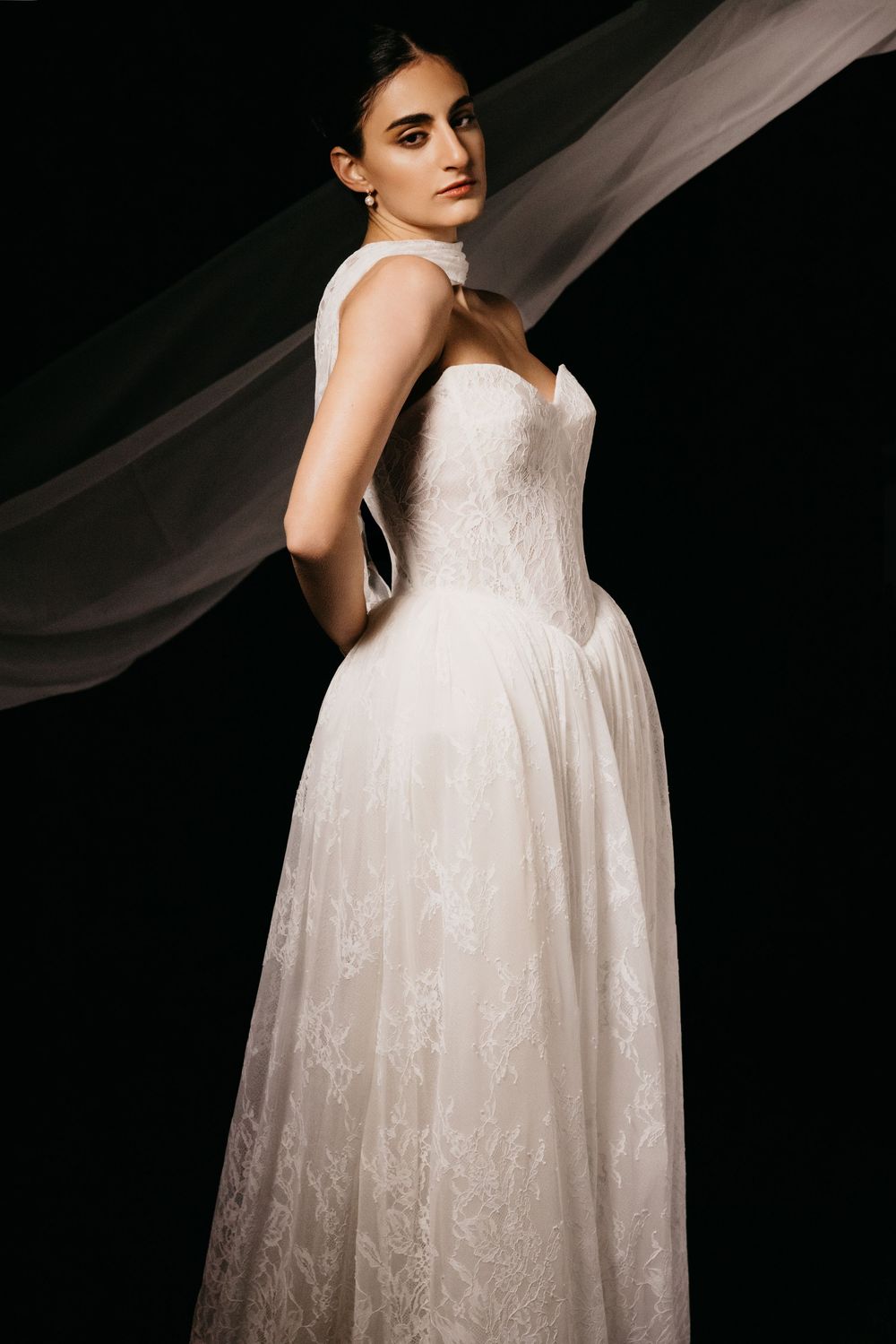 Model standing with hands behind back in lace wedding gown, Atlanta editorial portrait and fashion photographer