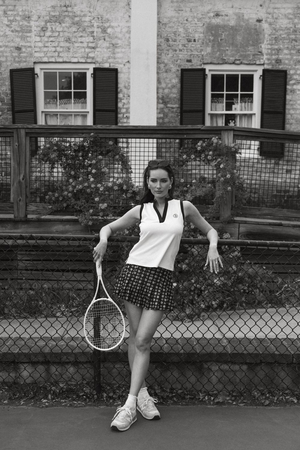 Model Chandler Bailey leans on tennis court fence with racquet, Atlanta editorial portrait and fashion photographer