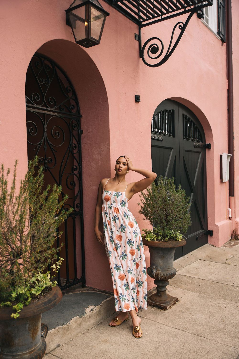 Editorial model leaning on pink stucco wall with resortwear dress, Atlanta editorial portrait and fashion photographer