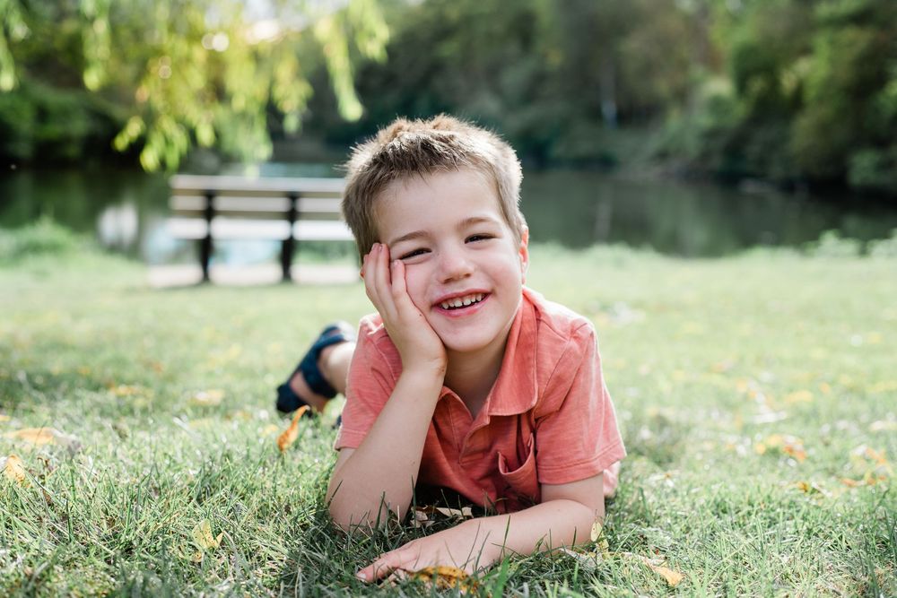 child smiles at camera in the grass
