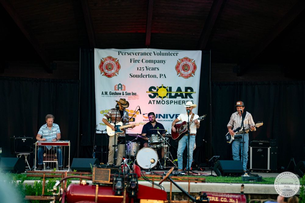 Live band performing on outdoor stage at Perseverance Volunteer Fire Company 125th anniversary event in Souderton, PA.