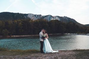 Esküvői kreatív fotózás tóparton, hegyekkel a háttérben.