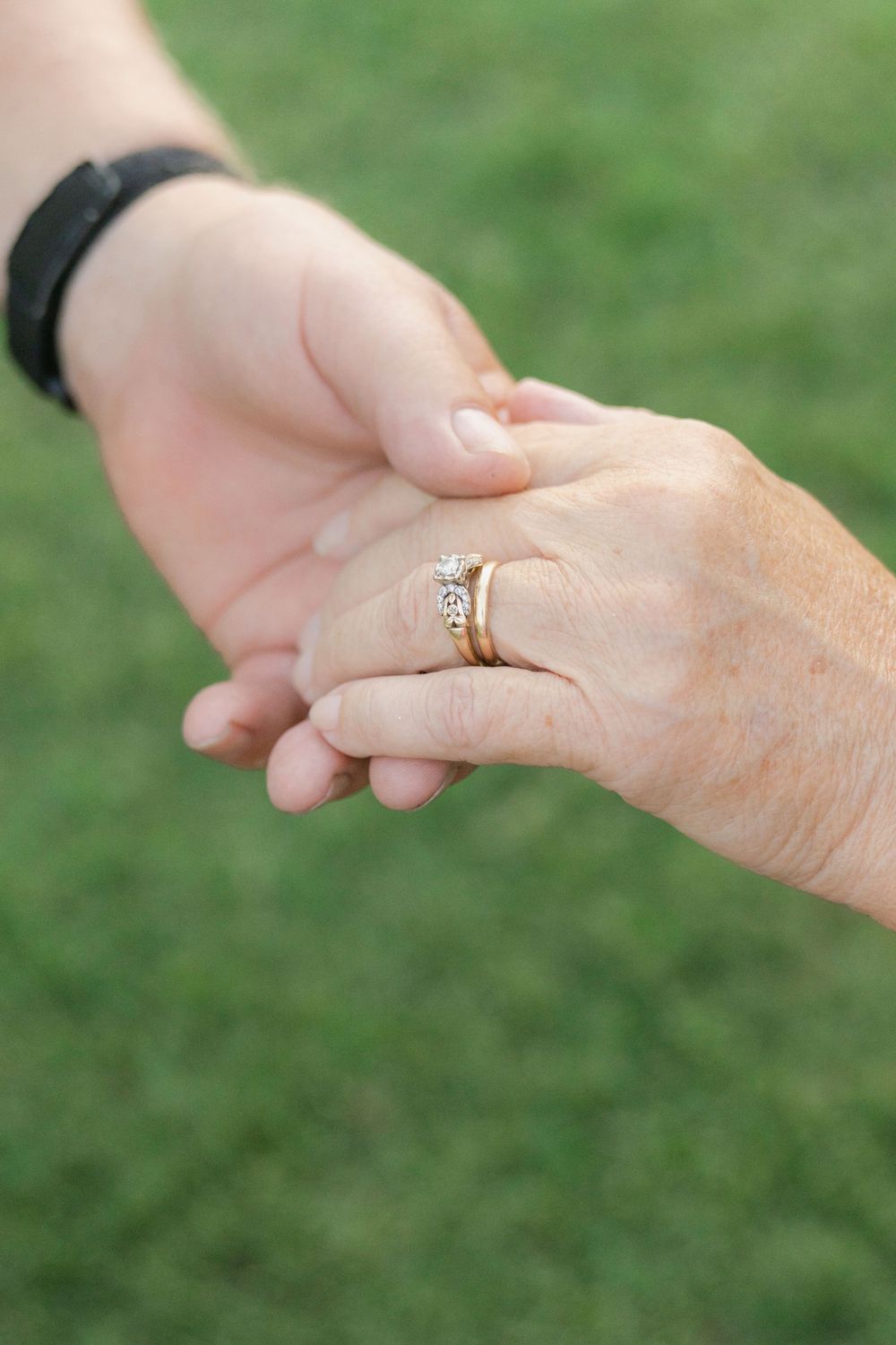 Close-up of Lori and Kenny holding hands, showing their wedding rings during their 45th anniversary portraits with Lindy Rebro