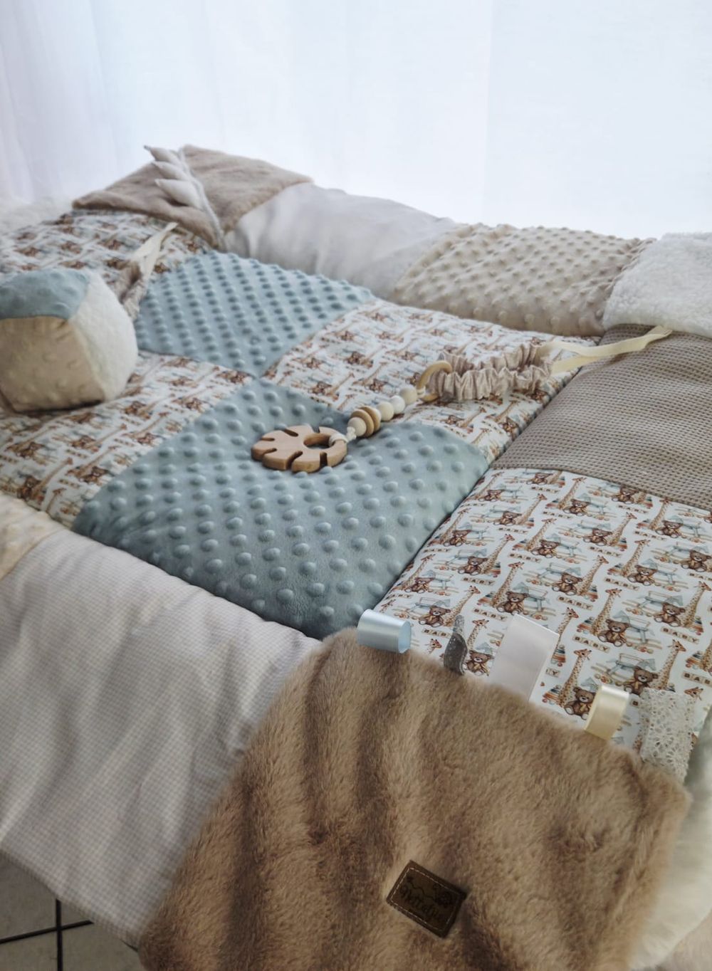 Handmade patchwork baby play mat in neutral tones featuring blue minky dots, bear print, and beige sherpa fabrics.