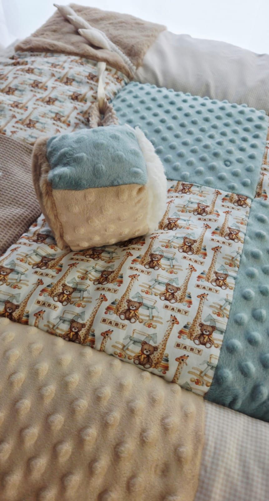 Baby quilt with giraffe and teddy bear print, teal minky dot fabric patches, and a matching soft cube toy.