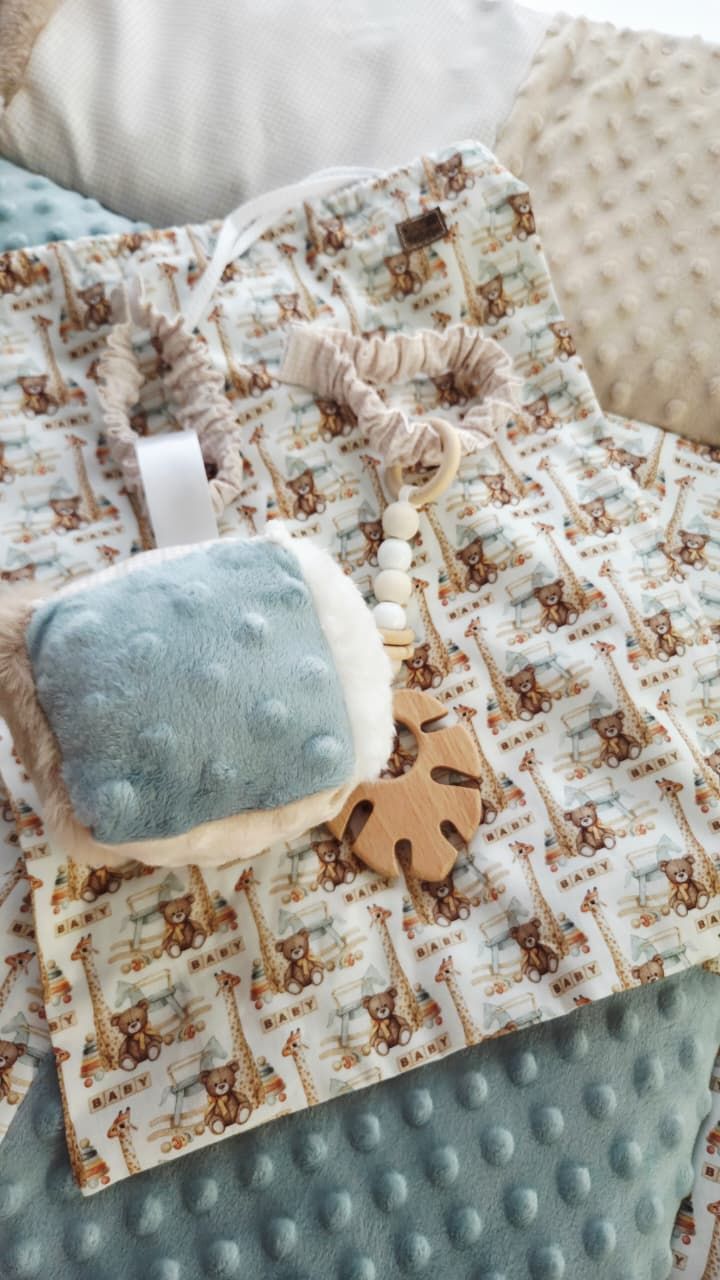 Baby blanket with safari animal print, minky dot fabric, and wooden teether toy with beaded clip attachment.