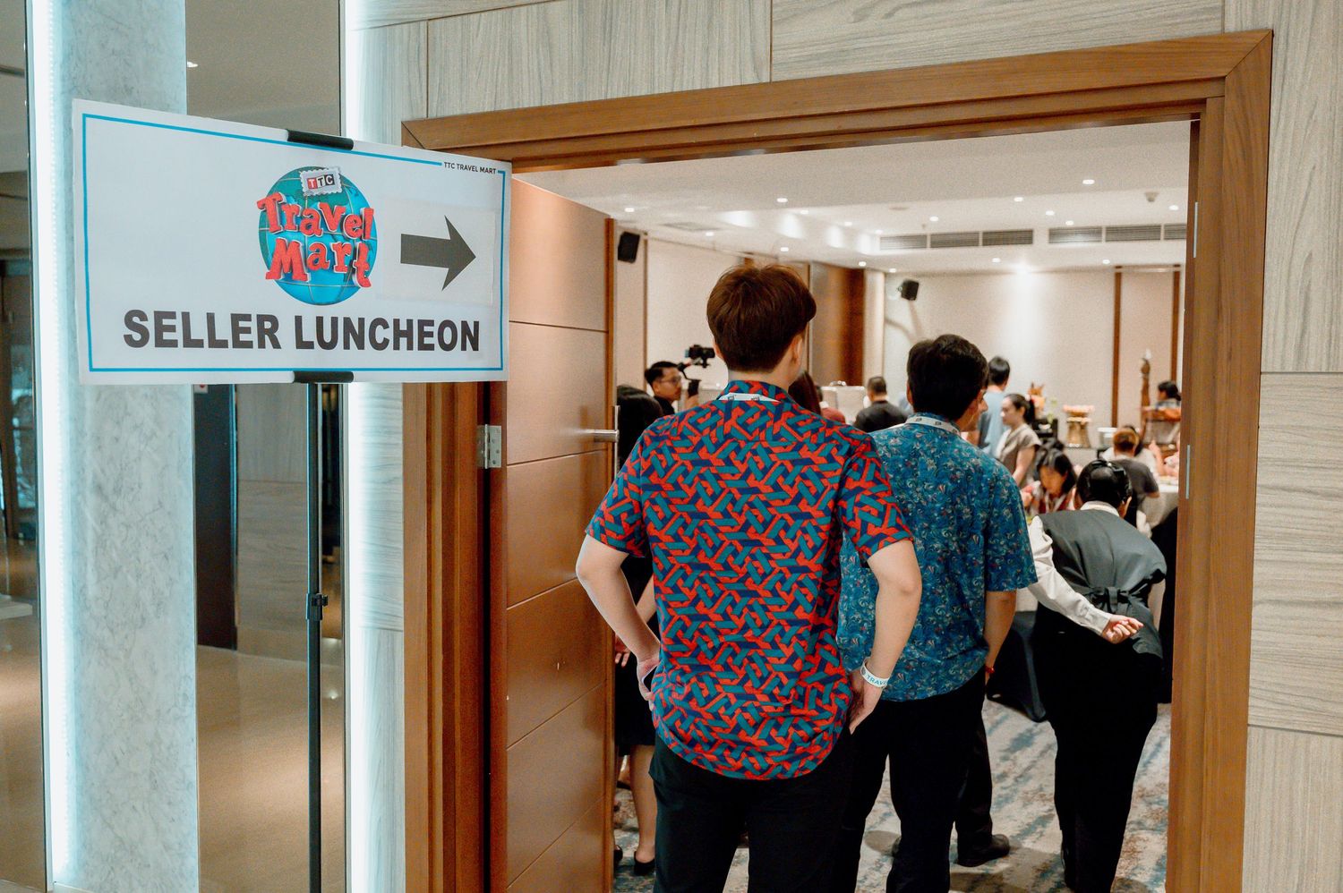 Attendees queue outside a Seller Luncheon event room at a busy conference venue.