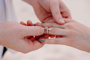 Close-up shots of hands exchanging an engagement ring.