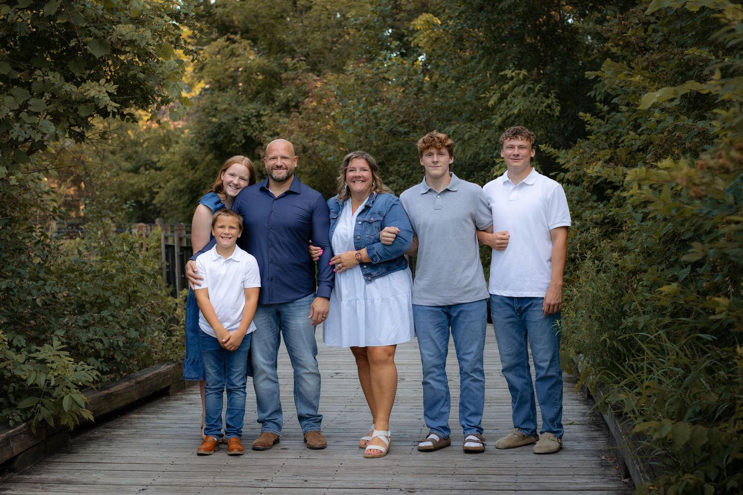 Fall family pictures outdoors at sunset on wooden boardwalk at Mill Creek Park in Dexter, MI by Brighton, Michigan photographer