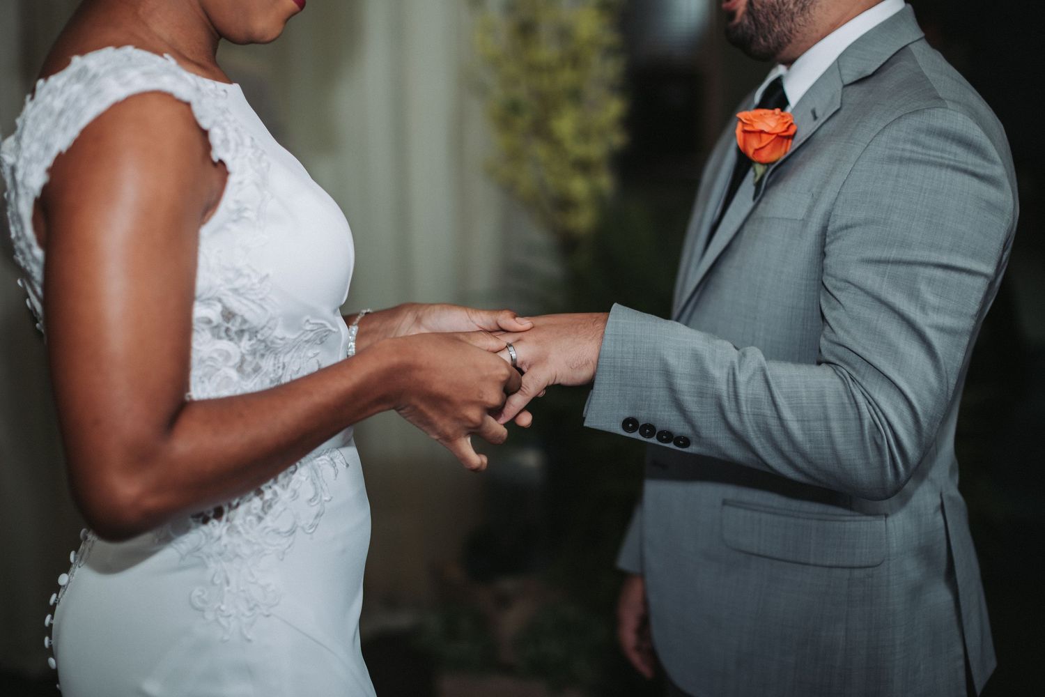 Close-up of hands exchanging wedding rings during an intimate ceremony.