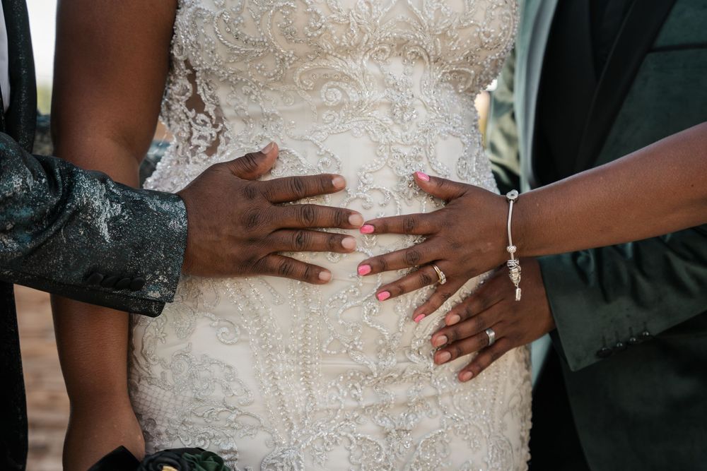 Close-up of hands with rings on a bride in a lace wedding dress, celebrating a beautiful wedding day.