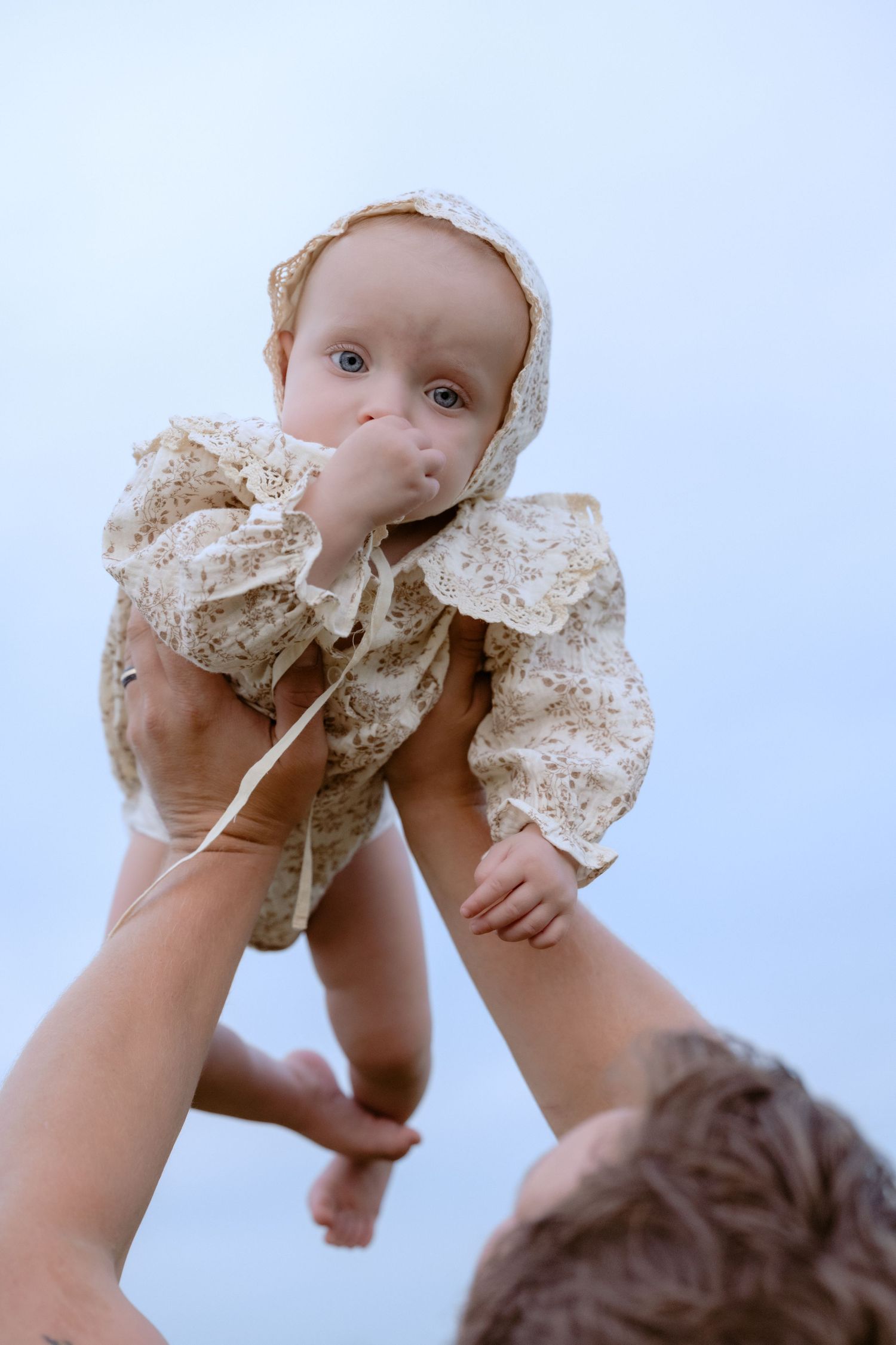 Dad holds baby girl up in the air during outdoor family photos in Hudson, WI.