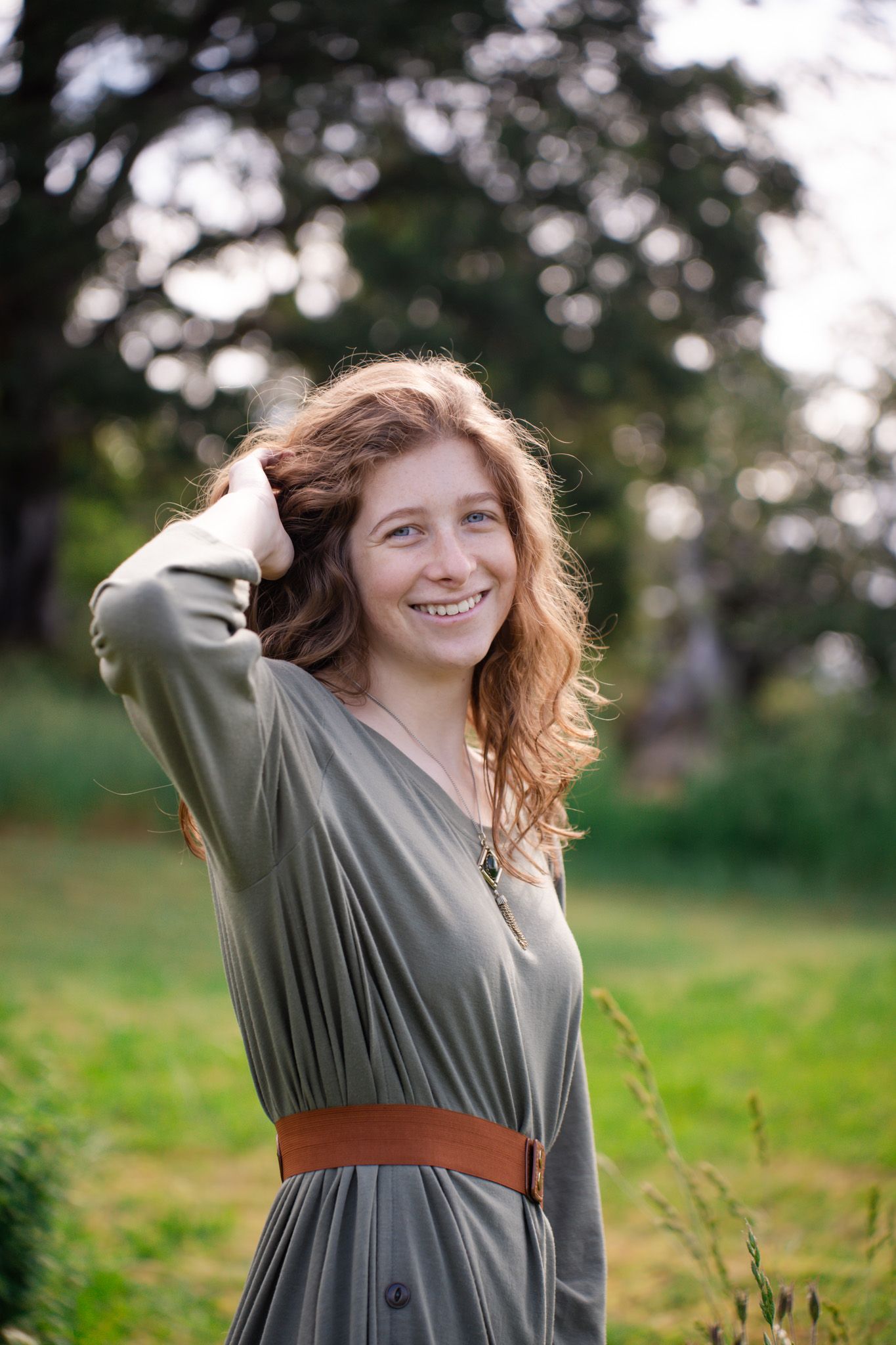 Senior portrait of a girl in a field with trees
