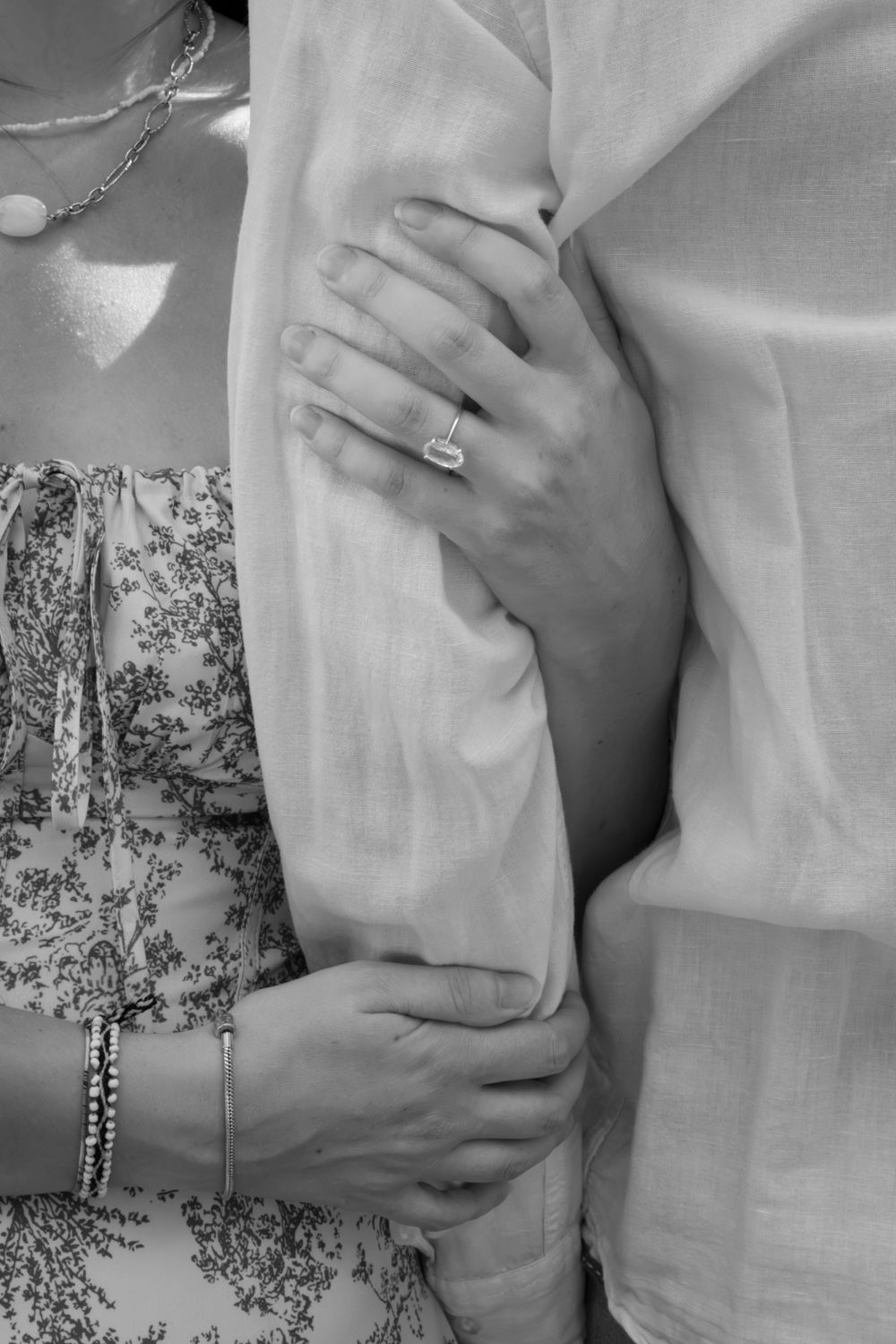 Gros plan en noir et blanc sur les mains d'un couple enlacé, séance photo de couple à Lyon