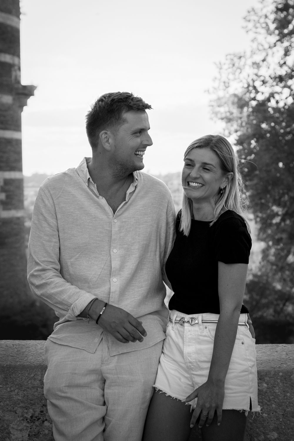 Couple en noir et blanc, lui en chemise claire, elle en haut noir, adossés à un mur, Angers