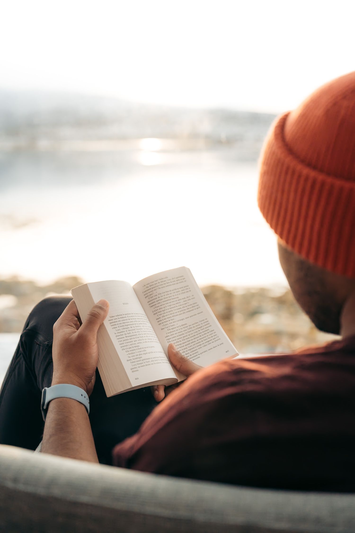 homme qui lit dans un hotel à senja avec une ambiance cocooning au coucher du soleil au bord du fjord