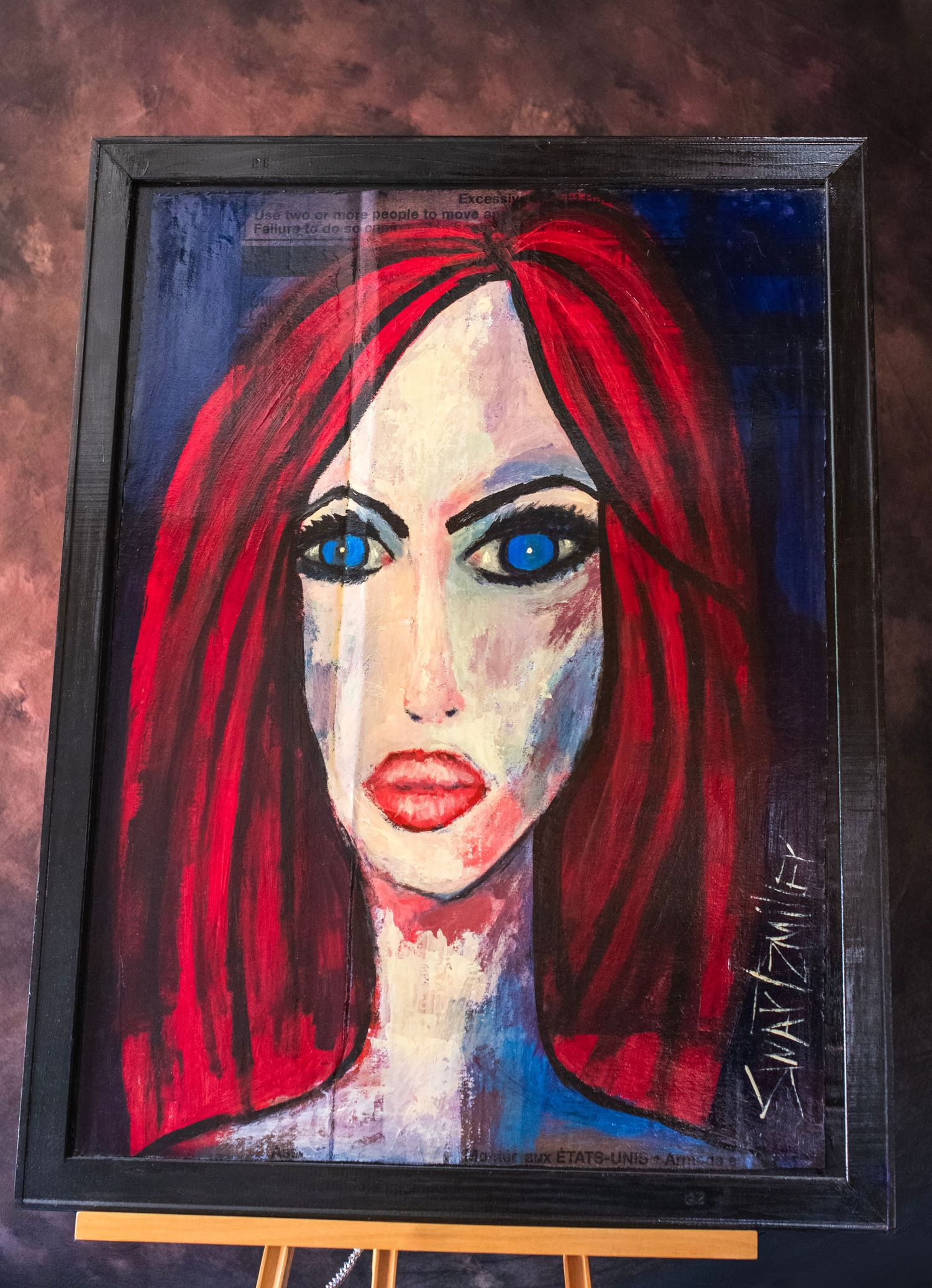 Framed acrylic painting of a woman with red hair and blue eyes in an expressive, bold style with blue and white tones.