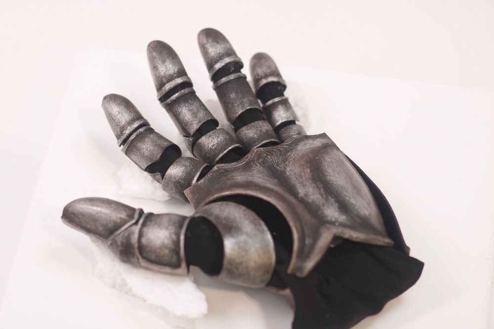 Medieval knight armored gauntlet glove prop, silver metallic finish, displayed on white surface.