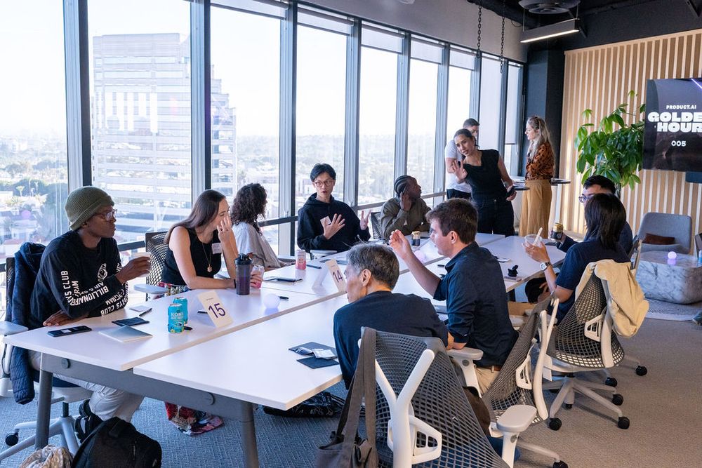 Group of young professionals collaborating at a modern office conference table with city skyline views.