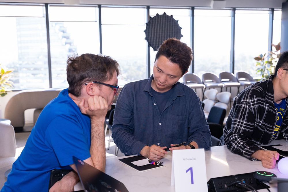 Three professionals collaborating at a numbered table during a business networking event.