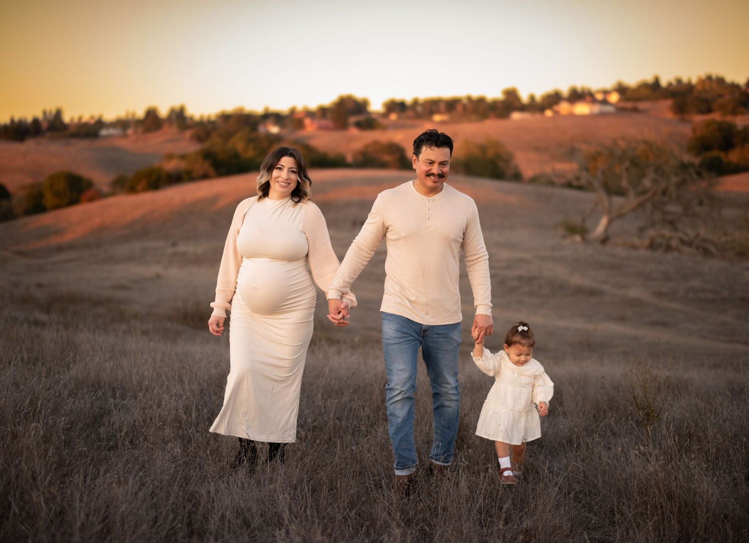 A family laughing and exploring together at Crane Creek, surrounded by open hills, tall grasses, and the beauty of Sonoma County.