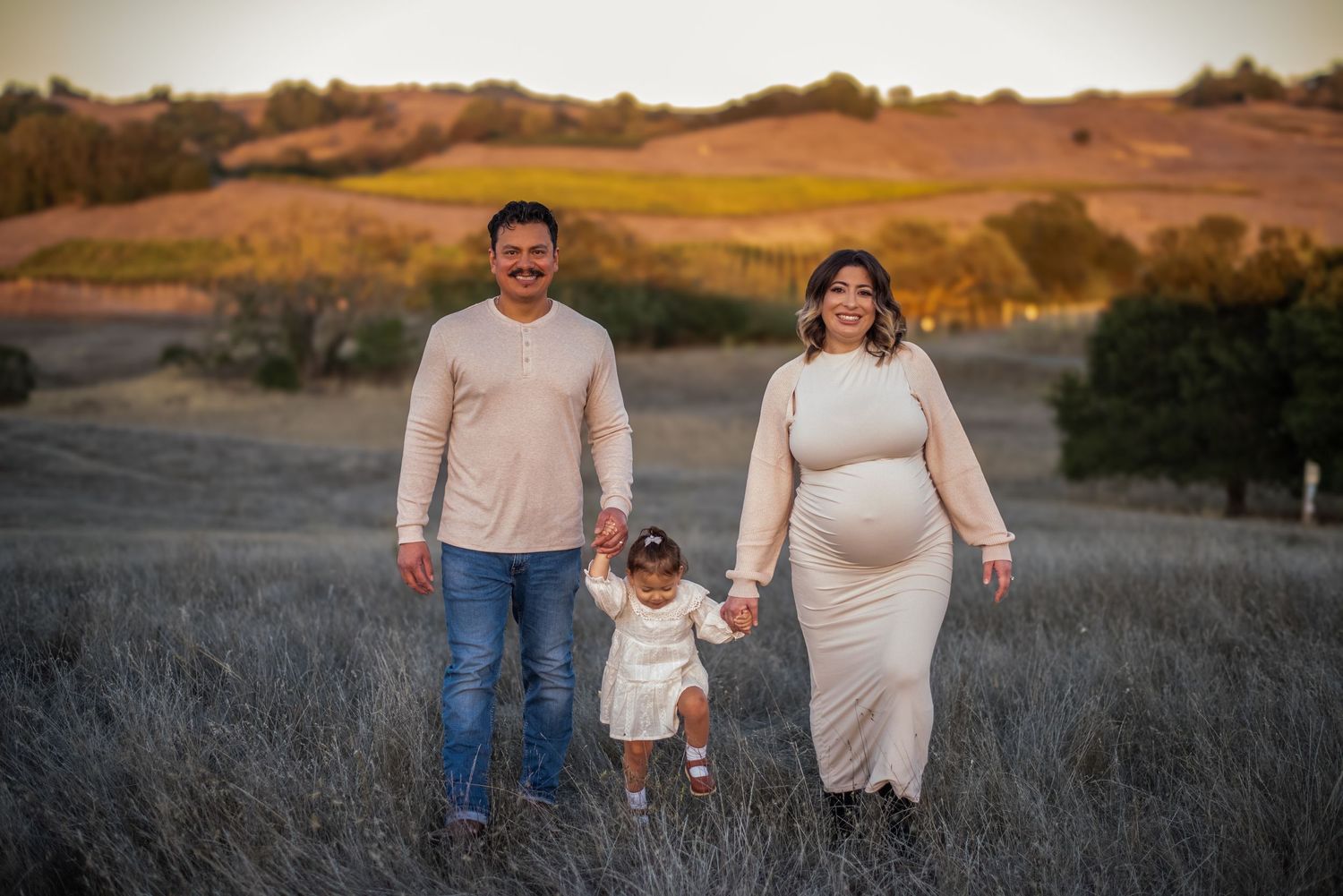 A family laughing and exploring together at Crane Creek, surrounded by open hills, tall grasses, and the beauty of Sonoma County.
