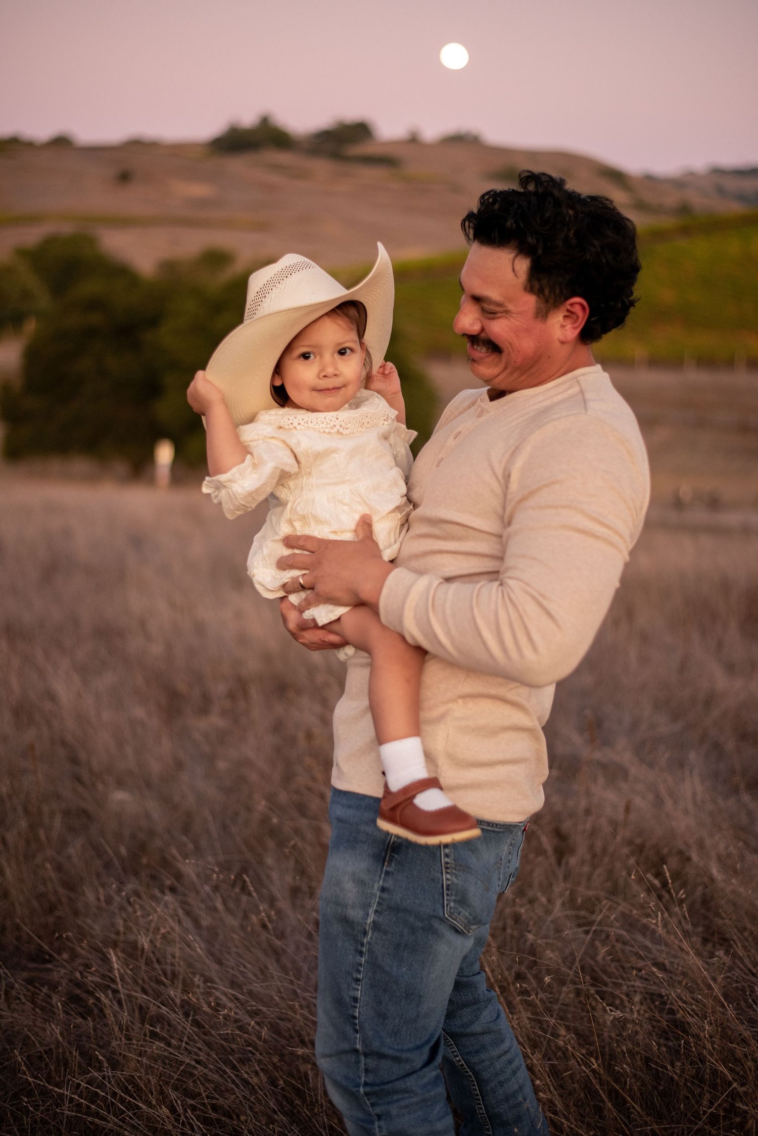 A family laughing and exploring together at Crane Creek, surrounded by open hills, tall grasses, and the beauty of Sonoma County.