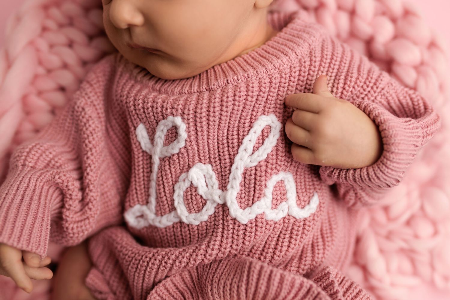 Pink knit newborn romper with white embroidered name Lola, perfect personalized baby outfit for girls.