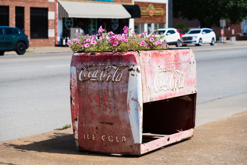Vintage CocaCola vending machine used as flower planter on a sidewalk in Sapulpa, OK. June 10, 2026. (David J. Manning)
