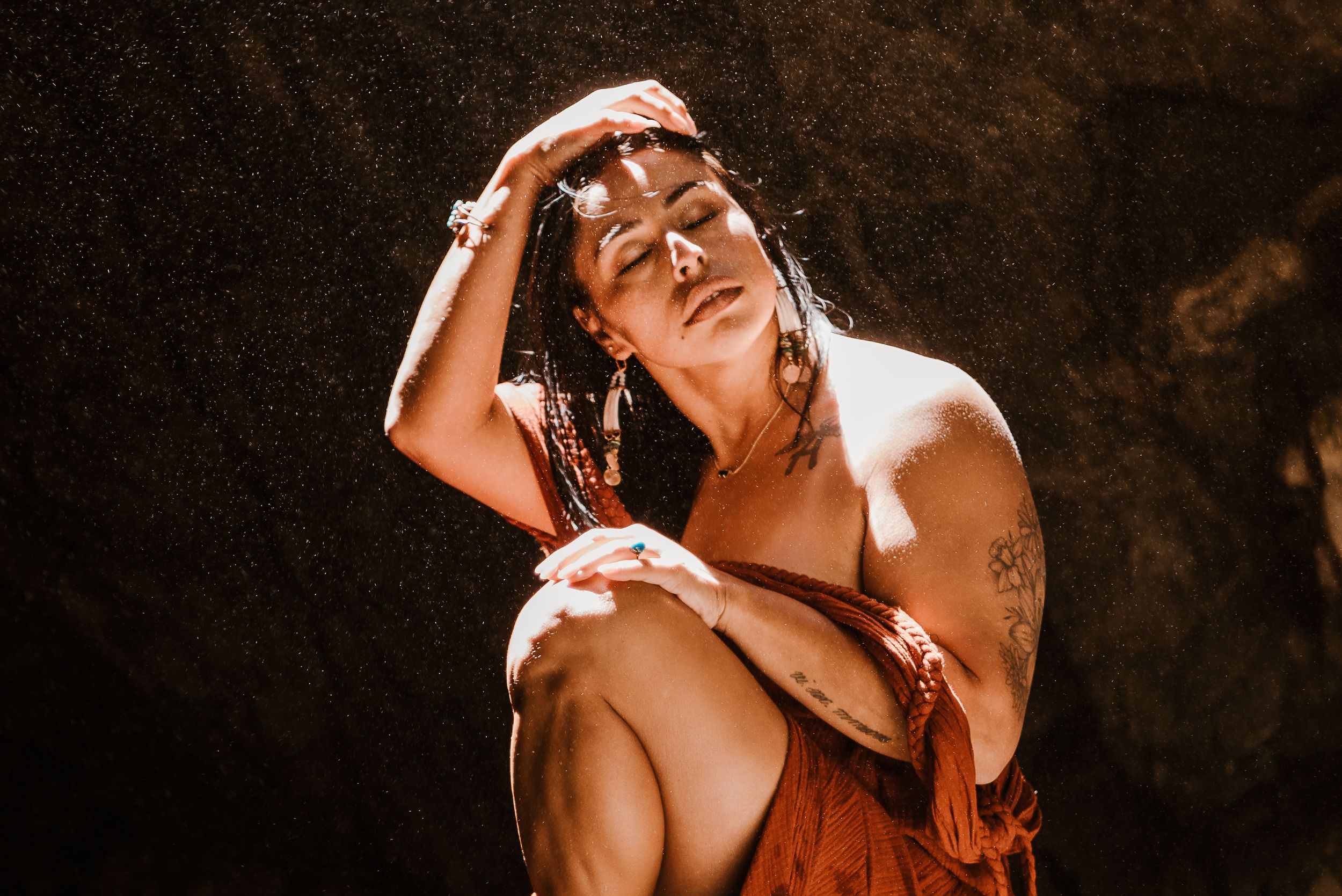 woman sitting pulling her hair away from her face.